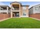 A backyard featuring a lush artificial lawn, a covered patio, and a balcony above at 175 Strada Fontana, Henderson, NV 89011