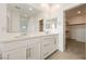 Bright bathroom featuring double sinks and a door leading into a large walk-in closet at 175 Strada Fontana, Henderson, NV 89011