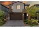Charming two-story home with a well-manicured front yard and a two-car garage at dusk at 175 Strada Fontana, Henderson, NV 89011