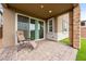 Relaxing covered patio featuring stone pavers, artificial grass, and an outdoor seating area at 175 Strada Fontana, Henderson, NV 89011
