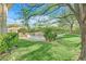 View of the backyard featuring a sparkling pool, lush green grass, and mature trees at 1809 White Hawk Ct, Las Vegas, NV 89134