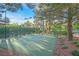 Outdoor basketball court enclosed with a fence and trees, complete with lighting for evening play at 1809 White Hawk Ct, Las Vegas, NV 89134