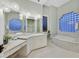 Spa-like bathroom with marble accents, a soaking tub, and decorative lighting, offering a luxurious experience at 1809 White Hawk Ct, Las Vegas, NV 89134