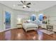 Bright bedroom featuring hardwood floors, a ceiling fan, and a door to the outside at 1809 White Hawk Ct, Las Vegas, NV 89134