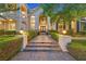 Exterior view of a home featuring a grand entrance with stone steps, lanterns, and trimmed hedges at 1809 White Hawk Ct, Las Vegas, NV 89134