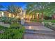 Exterior view of a home featuring a grand entrance with stone steps and lush landscaping at 1809 White Hawk Ct, Las Vegas, NV 89134