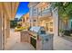 Outdoor kitchen with stainless steel grill, stone accents, and spacious patio area for entertaining at twilight at 1809 White Hawk Ct, Las Vegas, NV 89134