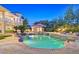 Beautiful pool area with lush landscaping, a spa, and a built-in waterfall feature at 1809 White Hawk Ct, Las Vegas, NV 89134