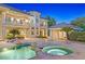 Inviting outdoor area featuring a sparkling pool, spa, and lush landscaping at dusk at 1809 White Hawk Ct, Las Vegas, NV 89134