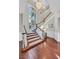 Grand foyer featuring a curved staircase, chandelier, and hardwood floors that offer a luxurious welcome at 1809 White Hawk Ct, Las Vegas, NV 89134