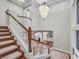 Elegant staircase with white balusters, wood handrails, and a view of the upper-level landing with high ceilings at 1809 White Hawk Ct, Las Vegas, NV 89134