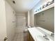 Standard bathroom with a combined shower and bathtub, tiled floor, single sink vanity and large mirror at 1881 W Alexander Rd # 2129, North Las Vegas, NV 89032