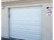 A bright white paneled garage door is seen on the exterior of the building next to a fire lane sign at 1881 W Alexander Rd # 2129, North Las Vegas, NV 89032