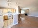 Bright kitchen featuring white appliances, tiled countertops, an island with bar seating, and an open view to the living room at 1881 W Alexander Rd # 2129, North Las Vegas, NV 89032