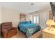 Comfortable bedroom features an upholstered chair, TV and bed with blue bedding at 1913 Madagascar Ln, Las Vegas, NV 89117