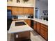 Well-lit kitchen with a central island, wood cabinets, and tiled flooring creating a cozy atmosphere at 1913 Madagascar Ln, Las Vegas, NV 89117