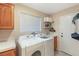 Well-lit laundry room with full size washer and dryer next to a wash sink at 1913 Madagascar Ln, Las Vegas, NV 89117