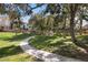 Curving walking path in a park-like green space with mature trees and grass at 1913 Madagascar Ln, Las Vegas, NV 89117