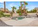 Landscaped backyard with palm trees around a uniquely shaped pool and spa at 1913 Madagascar Ln, Las Vegas, NV 89117