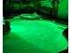 An in-ground swimming pool with beautiful LED lighting and rock accents at night at 1913 Madagascar Ln, Las Vegas, NV 89117