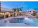 Tranquil backyard featuring a lagoon-style pool and spa, lush landscaping, and covered patio at 1913 Madagascar Ln, Las Vegas, NV 89117