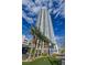 Modern high-rise condo building with stunning architecture and palm trees against a blue sky at 200 W Sahara Ave # 3510, Las Vegas, NV 89102