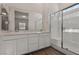 Bright bathroom featuring a double sink vanity, a glass enclosed shower, and hardwood floors at 209 Bellini Peak Ave, Henderson, NV 89011