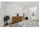 Bright bedroom with a wooden dresser, a plant, and a view into the bathroom area at 209 Bellini Peak Ave, Henderson, NV 89011