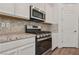 Modern kitchen features stainless steel appliances, white cabinetry, and marble countertops at 209 Bellini Peak Ave, Henderson, NV 89011