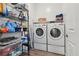 Organized laundry room with stacked washer and dryer, shelving, and ample storage space at 209 Bellini Peak Ave, Henderson, NV 89011