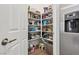 Walk-in pantry with lots of shelving and next to a stainless steel fridge at 209 Bellini Peak Ave, Henderson, NV 89011