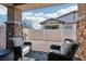 Inviting covered patio with stone pillars, brick flooring, comfortable seating, and a built-in grill at 209 Bellini Peak Ave, Henderson, NV 89011
