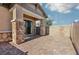 A covered outdoor patio with brick flooring, stone-clad pillars, and access to the backyard at 209 Bellini Peak Ave, Henderson, NV 89011