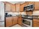 Kitchen with wood cabinetry, stainless steel oven, and dark countertops at 2453 Vivid Sky Pl, Henderson, NV 89044