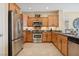 Well-lit kitchen featuring stainless steel appliances, wood cabinets, and granite countertops at 2453 Vivid Sky Pl, Henderson, NV 89044