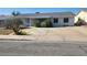 Modest single-story home featuring desert landscaping, a wide driveway, and window bars for added security at 255 Winona Dr, Henderson, NV 89015