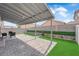 Outdoor patio with a covered seating area and well-maintained artificial grass at 2633 Spider Cactus Ct, Las Vegas, NV 89106