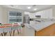 Modern kitchen with white cabinets, stainless steel appliances, and a dining area with sliding glass doors at 2633 Spider Cactus Ct, Las Vegas, NV 89106