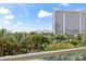 Relax on your balcony with scenic views of lush palm trees and a prominent hotel in the distance at 2857 Paradise Rd # 401, Las Vegas, NV 89109