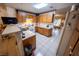 Kitchen with laminate countertops, wood cabinets, white appliances, tile flooring, and bar seating at 2906 Cedar Ave, Las Vegas, NV 89101