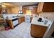 Kitchen with laminate countertops, wood cabinets, white appliances, tile flooring, and breakfast bar at 2906 Cedar Ave, Las Vegas, NV 89101
