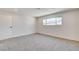 Large carpeted bedroom offering base moulding, white door, and large window at 3386 El Camino Real, Las Vegas, NV 89121