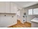 Bright laundry room with white cabinets, modern countertops, and wood-look flooring at 3386 El Camino Real, Las Vegas, NV 89121