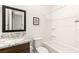 Bathroom featuring granite countertop vanity, framed mirror, and white tub with shower at 3395 Stone View Ave, Henderson, NV 89044