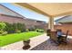 A covered patio with a dining set provides a comfortable outdoor living space with lush green landscaping at 3395 Stone View Ave, Henderson, NV 89044