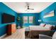 Stylish bedroom features blue walls, a modern ceiling fan, and comfortable modern furnishings at 3395 Stone View Ave, Henderson, NV 89044