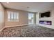 A modern living room with a fireplace, custom TV, and lots of natural light at 3892 Pasilla Ave, Las Vegas, NV 89118