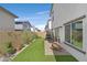 Well-maintained backyard featuring artificial turf, a small patio area, and a charming rocking chair at 392 Canary Song Dr, Henderson, NV 89011