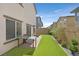 Backyard featuring artificial turf, a patio area with table, and landscaping along the fence at 392 Canary Song Dr, Henderson, NV 89011