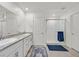 Bathroom with double sink vanity, shower and a neutral toned tile floor at 392 Canary Song Dr, Henderson, NV 89011
